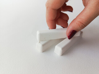 A hand takes school chalk from the table. Advertising background, space for text.