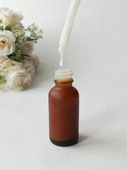 Serum from a pipette drips into a bottle. Moisturizing cream for the skin of hands and face. Cosmetic care products. Background for advertising.