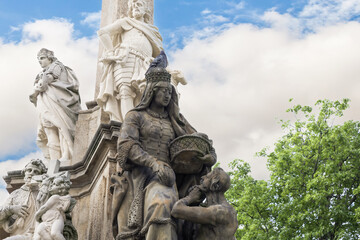 One of the sculptures at the bottom of the Marian Plague Column in garden on Hradcanska Square in Prague in Czech Republic