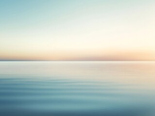 Obraz premium A serene seascape at dawn with calm waters reflecting soft pastel hues of the sky.