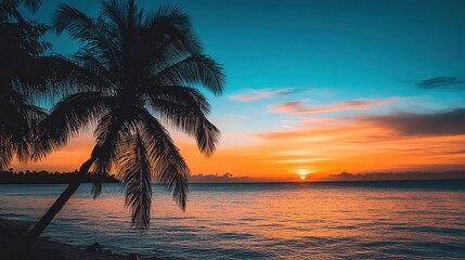Obraz premium Stunning sunset over calm waters with palm trees silhouetted along a tranquil beach at twilight