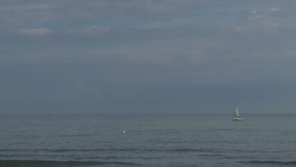 Obraz premium Slow-motion sailing of yacht near beach buoy