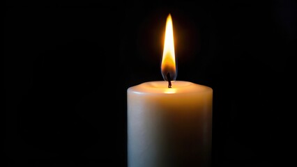 White candles burning in the dark with focus on a single candle in the foreground