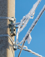 A pole with a wire on it covered in ice