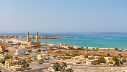 Obraz premium scenic landscape of bukha, a coastal town in Musandam, Oman, with a mosque and turquoise sea