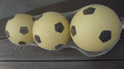 Three neatly arranged plastic balls that are on the sidelines during the day
