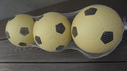 Three neatly arranged plastic balls that are on the sidelines during the day
