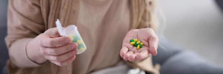 Woman holds in hand pills with vitamins to maintain body