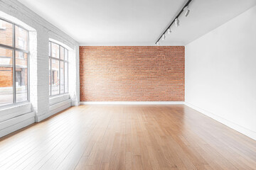 Fototapeta premium Spacious empty interior of a modern gallery with brick wall and large windows during daylight