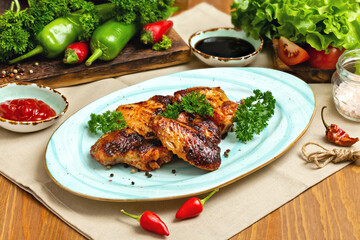 Grilled chicken wings on a plate. Cafe, lunch.