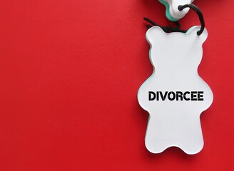 A paper bear on red copy space background with text written DIVORCEE - man or woman who formal...