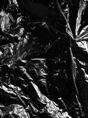 Wrinkled plastic wrap texture on a black background