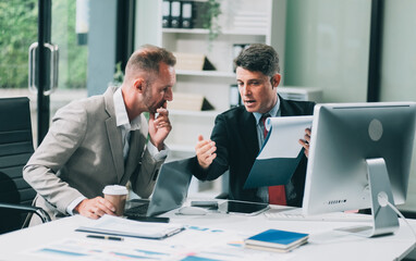 Two businessmen working together Analyze financial reports with charts and graphs while using the calculator to calculate budget, income, taxes, business growth. Startup business idea.