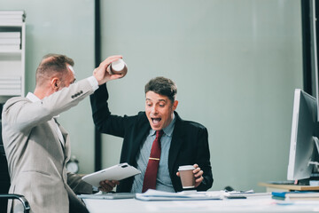 Two happy colleagues with laptop and documents in office