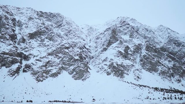 A snowy winter landscape in Jispa, Himachal Pradesh, India. The snowcapped peaks of the Himalaya mountain Range during moody winter day.