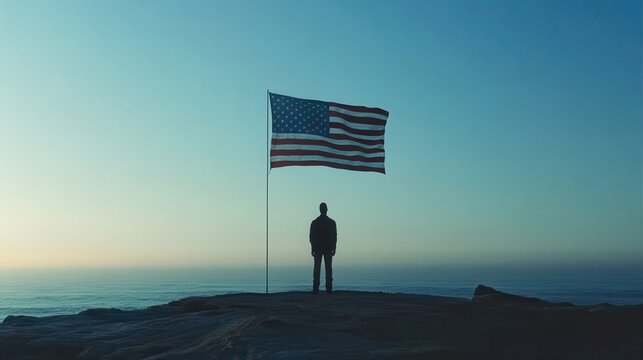 Silhouette of person with American flag at sunset on cliff - Powered by Adobe
