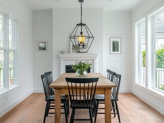 White wooden table with black chairs, white walls, and a black geometric pendant light for an interesting contrast