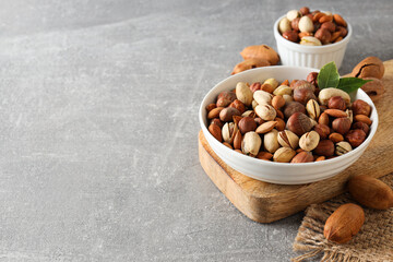 Assorted nuts in white bowls on a gray background