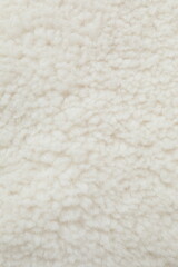 White cuddle teddy bear fabric as background, top view