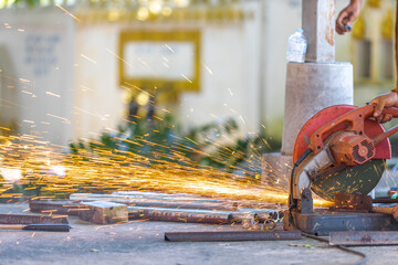 Blurred background of a craftsman using a machine, a saw blade cutting metal and sparks of scrap metal coming out. Use of tools and technology in construction.