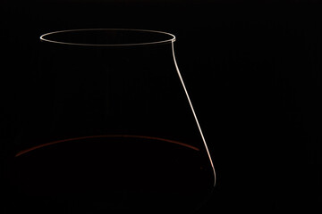 White and red linear silhouette of wine glass bowl on black.