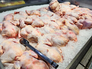 Fresh chickens displayed on ice in a supermarket. Perfect for roasting or grilling, ensures quality and freshness. Ideal for advertising, menus, or culinary blogs, highlighting premium meat