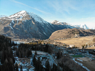 Aerial view of La Thuile ski village, with snowy mountain peaks in the background on a beautiful sunny morning