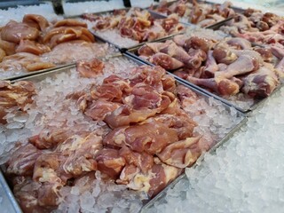 Fresh chickens displayed on ice in a supermarket. Perfect for roasting or grilling, ensures quality and freshness. Ideal for advertising, menus, or culinary blogs, highlighting premium meat