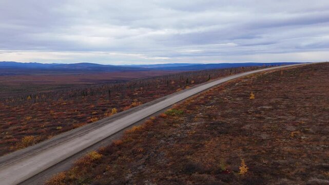 Paved Road Of Dempster Highway Through Autumn Nature Of Eagle Plains In Yukon, Canada. Aerial Drone Shot
