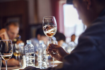 Person Swirling Glass of Wine at Table
