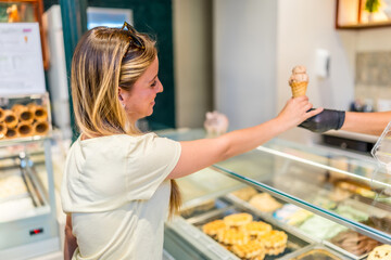 Smiling blonde woman shopping ice cream cone