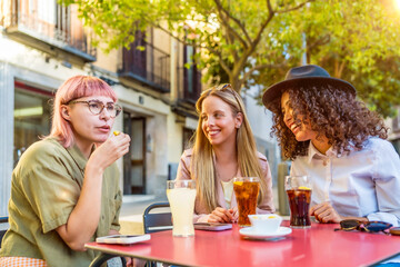 Stylish woman eating snacks and drinking in an outdoor cafeteria