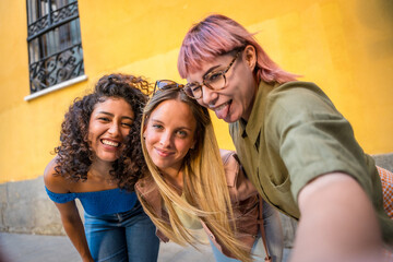 Fototapeta premium Happy friends grimacing while taking selfie in the street