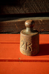 rusty old two kilogram weight in sunlight outdoors