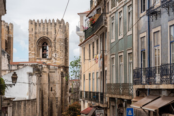 Obraz premium Bell tower of the Lisbon cathedral and residential houses at Rua Augusto Rosa