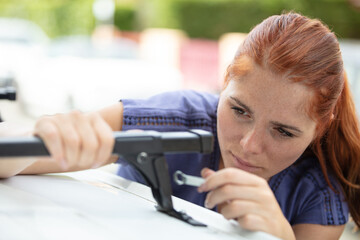 portrait of young woman installing a car roof