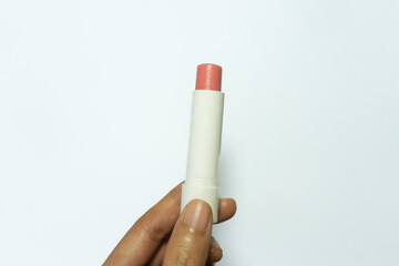 Young woman's hand holding lip balm isolated on white background