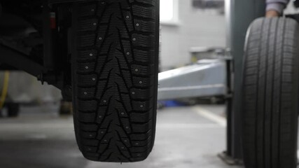 Car on a lift during tire change. 