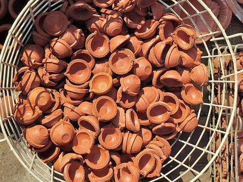 Hand made clay diye for sell in the market on the occasion of dipawali festival in india. Hand made clay diye or earthen lamp lighting in diwali night. People shoping for diwali festival. 