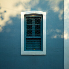 Blue iron and wooden color window with blue color concrete wall on the side of tree shadow, white town building concrete walls for photo shoot