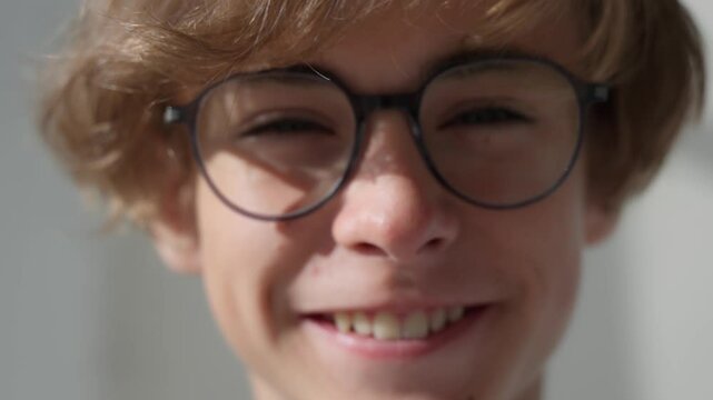 Student teenager man putting on glasses, smiling, happy guy looking at the camera, young male model student standing and posing. ophthalmologist visit. Close up eyes glasses