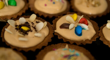 Detail of small cupcakes on black plate