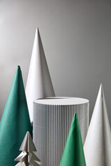 Christmas theme photo in modern style was shot on silver background from front view. An empty platform surround in center by cone blocks of silver and green color