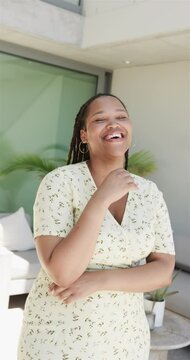 Vertical video: Biracial woman laughing, standing outside