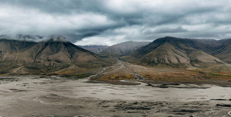 Dramatic landscape of barren mountains and valleys in Svalbard under a cloudy sky