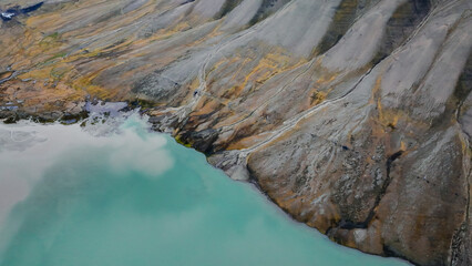 Unique aerial view of Svalbards rugged terrain and turquoise waters under a clear sky