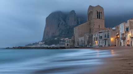 Serene long exposure of a tranquil beach with a historic church silhouette at sunset.