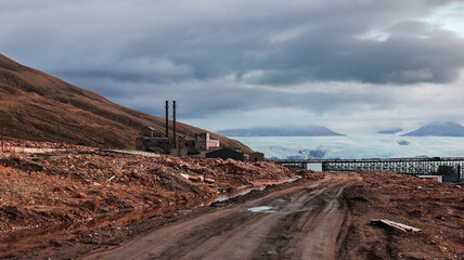 Exploring the remnants of Pyramiden in Svalbard during a cloudy day with glacier views