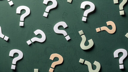 Scattered question marks on green surface symbolizing mystery, curiosity, and search for answers in life