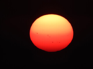 extremely zoomed sun at the sunset by the sea